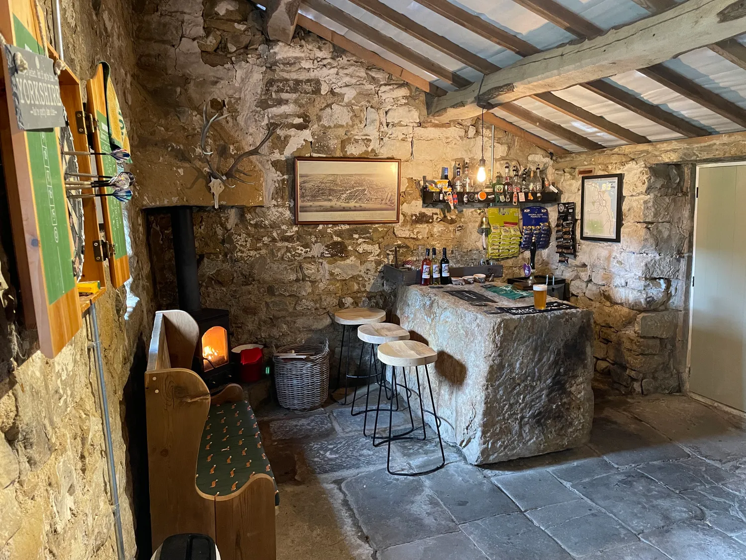 The stone bar and wood-burning stove inside The Stumble Inn