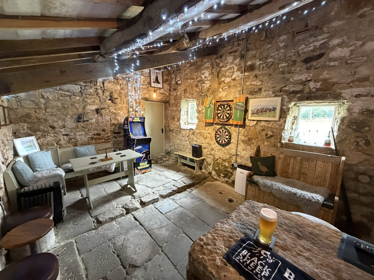 The seating and arcade machine inside The Stumble Inn